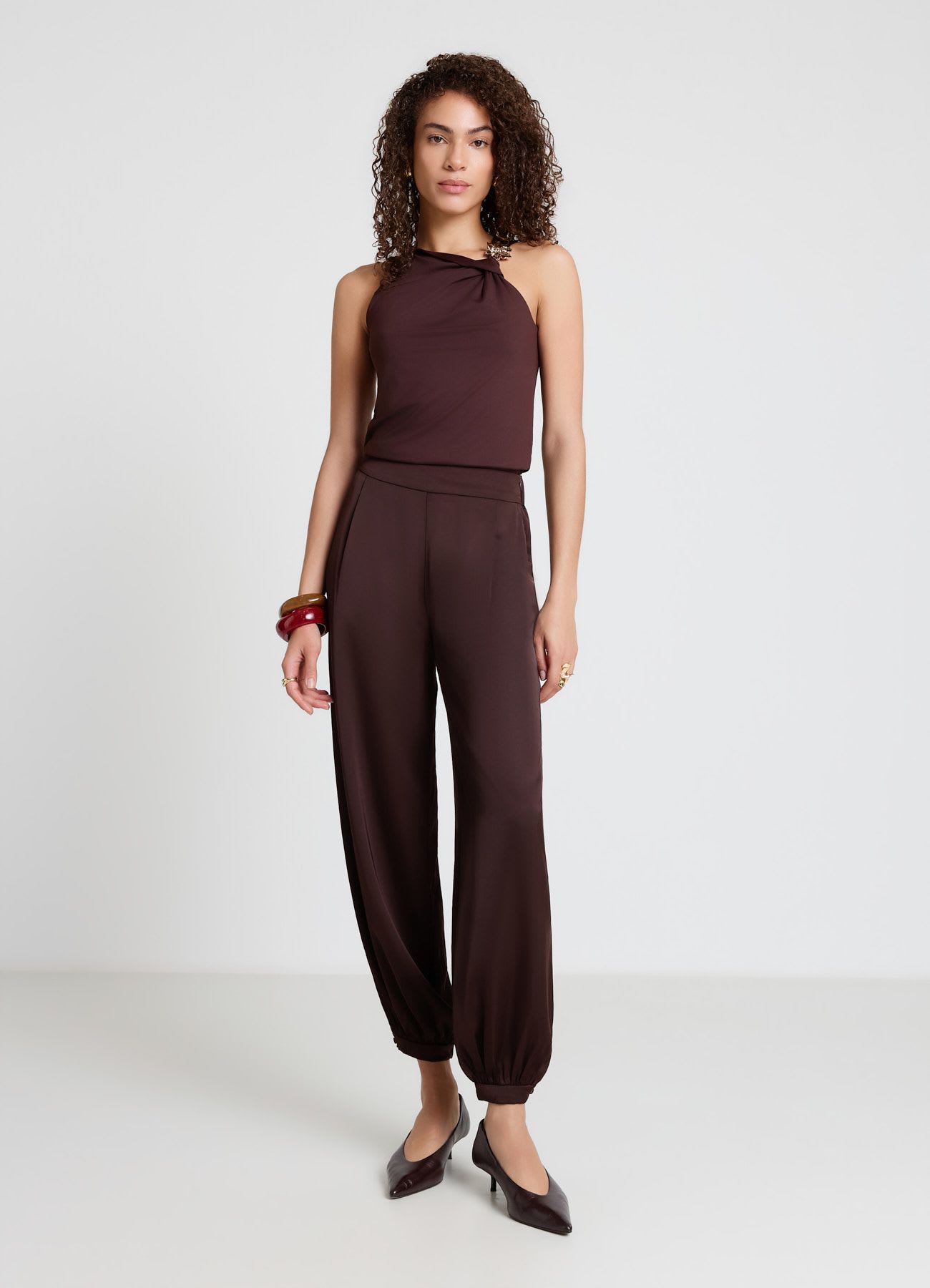 Top con scollo asimmetrico e spilla a fiore
