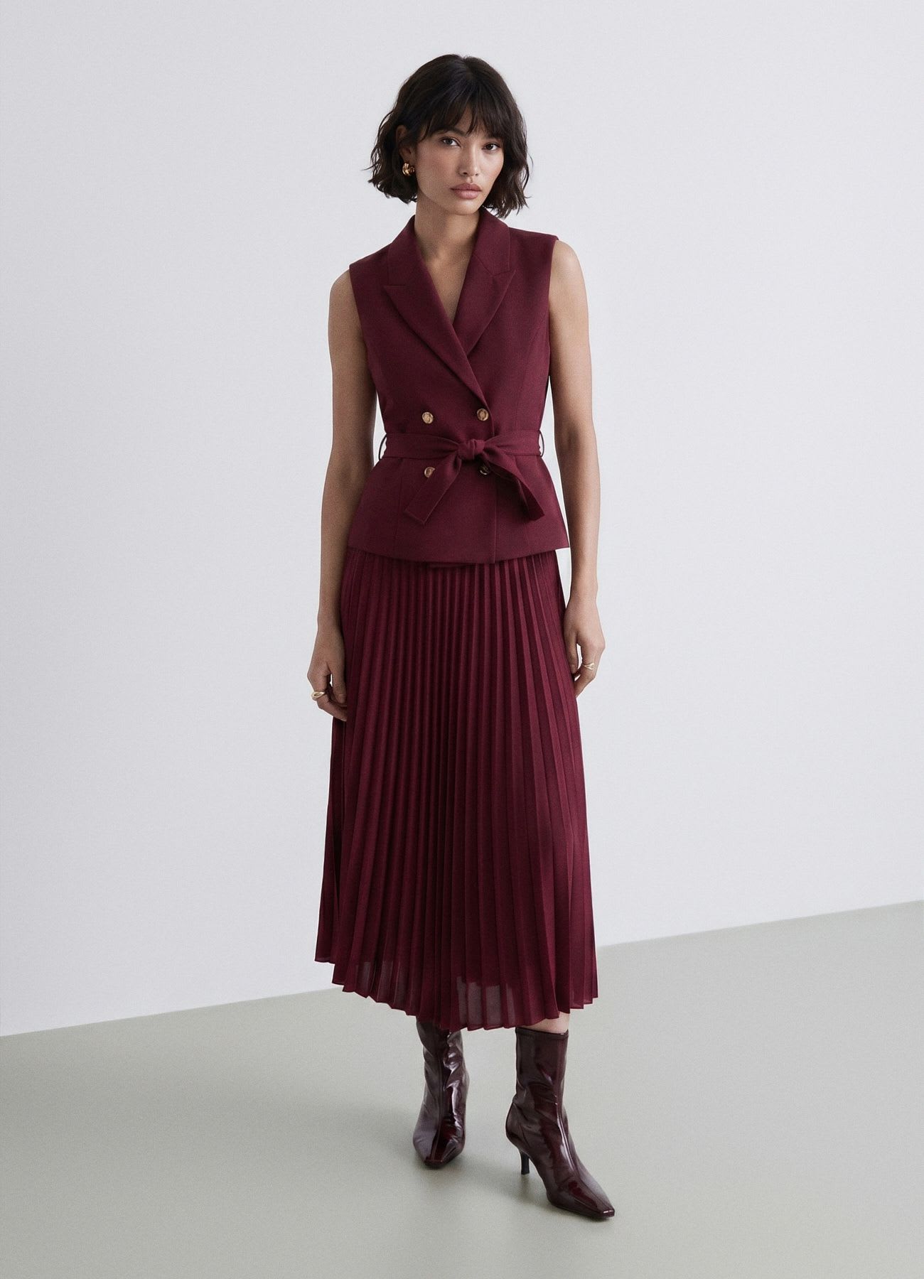 Vestito gilet doppiopetto con cintura e gonna plissé