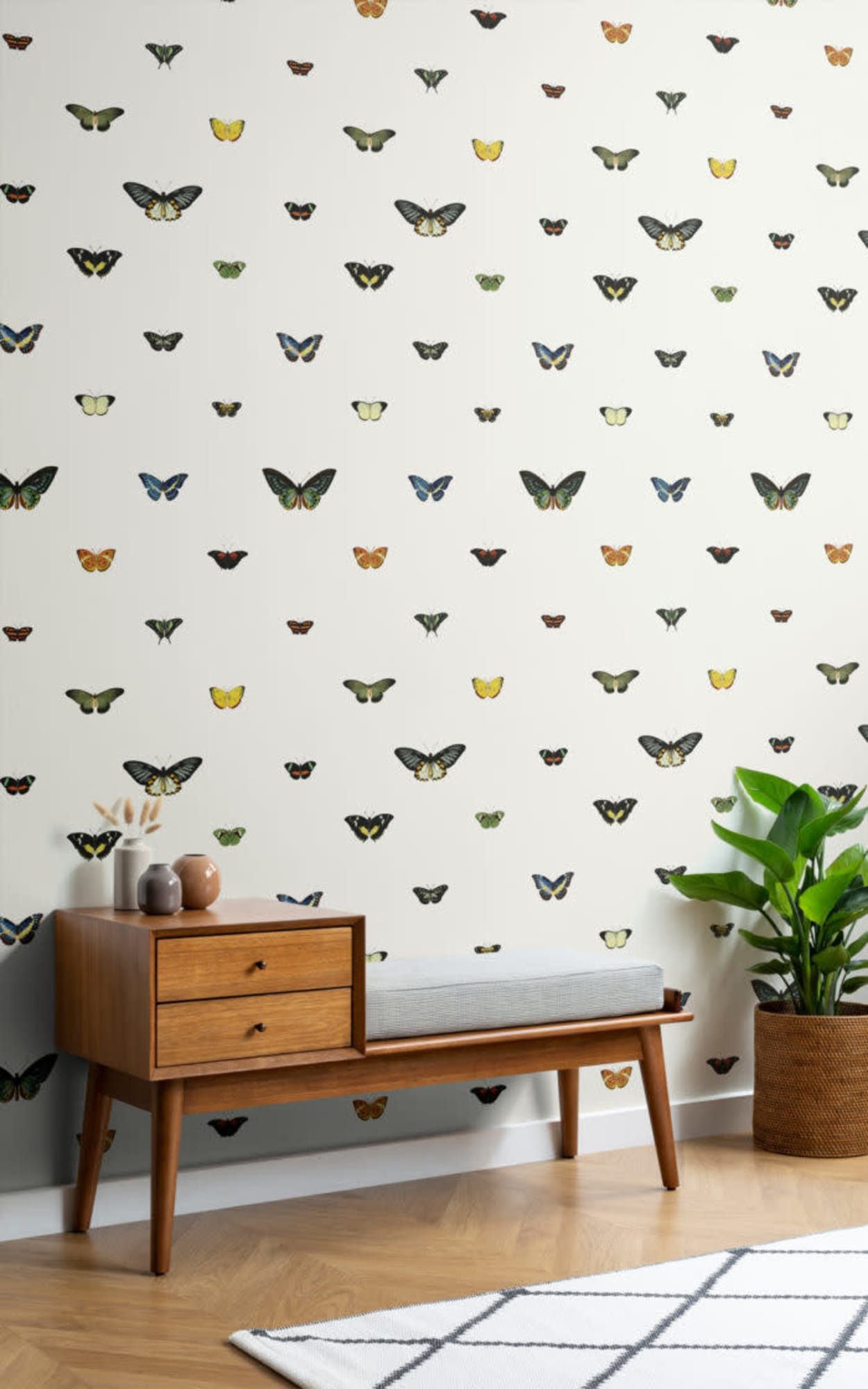 The room is brightened by a whimsical wallpaper adorned with a colorful array of butterflies, paired with mid-century modern furniture and vibrant green plants, creating a cheerful and lively space.