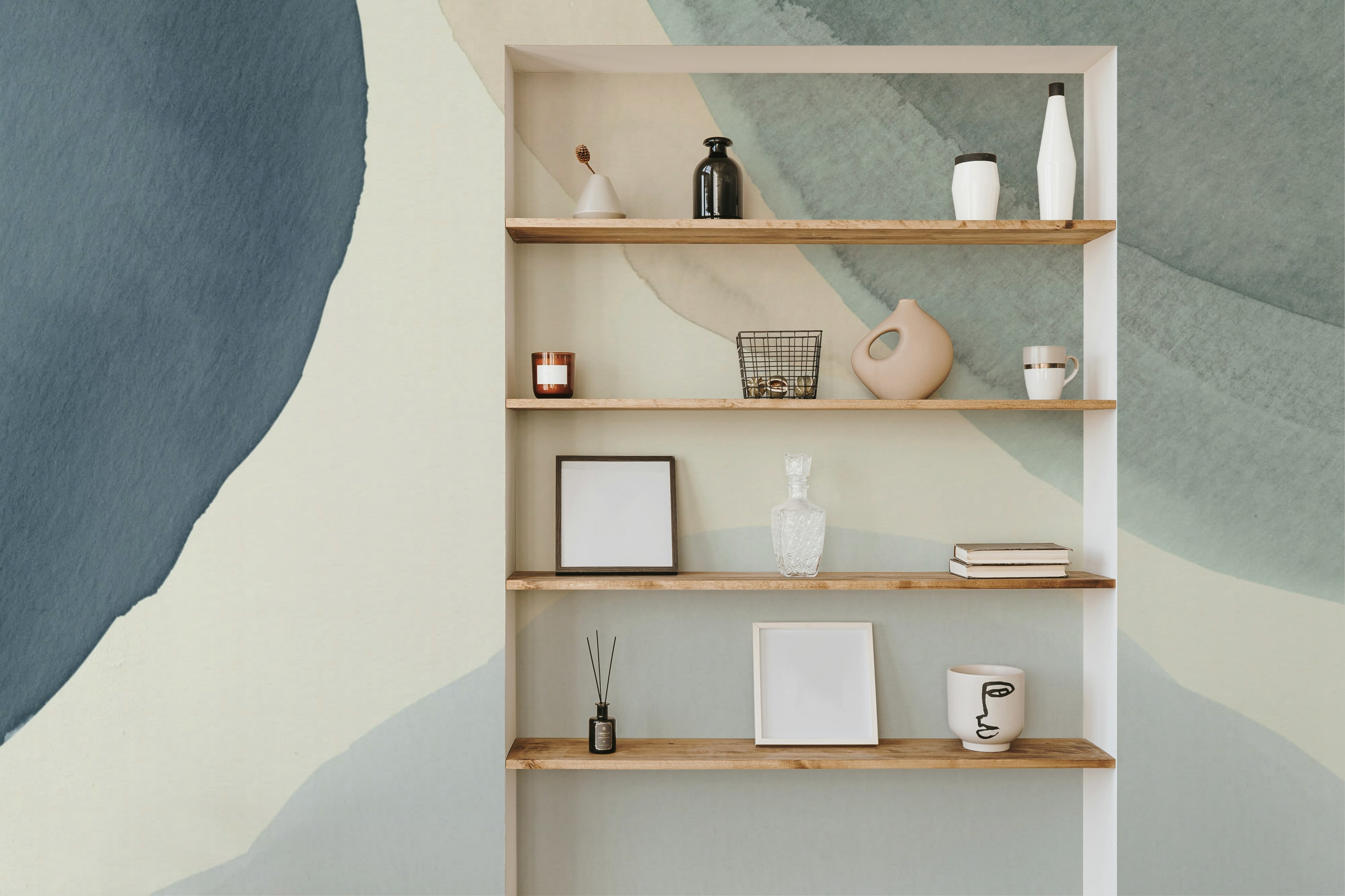 A stylish alcove with wooden shelves against a large-scale blue and beige abstract watercolor mural.