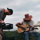 Photo of a man filming another man playing the guitar by Jakob Owens on Unsplash