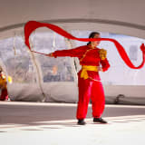 Photo of a woman performing a traditional Asian dance at a festival by Mick Haupt on Unsplash