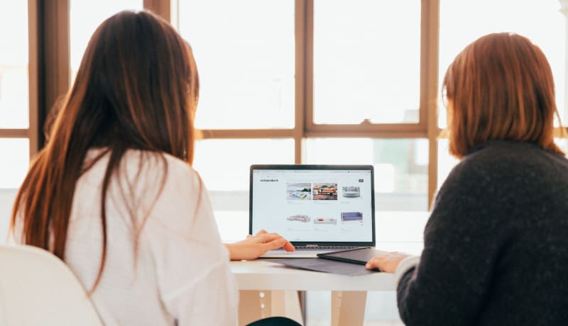 Photo of two people looking at a computer screen by KOBU Agency on Unsplash