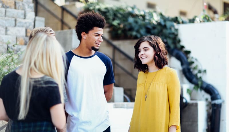 Photo of teenagers standing and talking by Alexis Brown on Unsplash