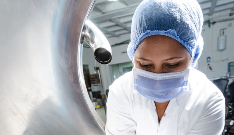 Photo of a woman checking food in a factory by Walter Otto on Unsplash