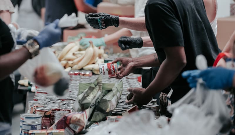 Photo of people handing out food at a food bank by Joel Muniz on Unsplash