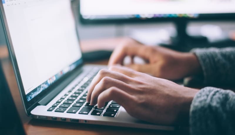 Picture of hands typing on a laptop by Glenn Carstens-Peters on Unsplash