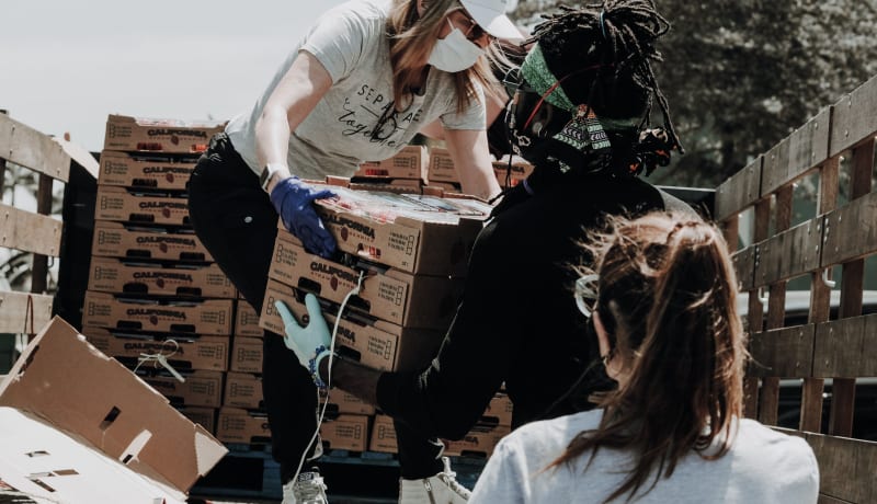 Photo of women lifting boxes of food by Joel Muniz on Unsplash