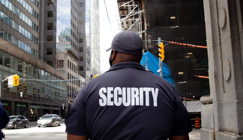 Photo of Security guard in uniform patrolling in a commercial area by Flex Point Security on Unpslash