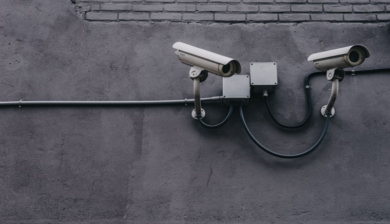 Photo of 2 security cameras on a wall by Scott Webb on Unsplash