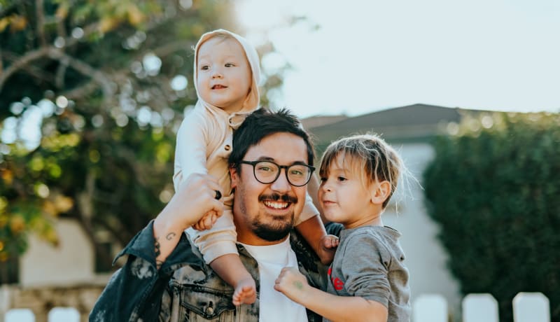 A photo of a father and his 2 children in front of a house by Nathan Dumlao on Unsplash