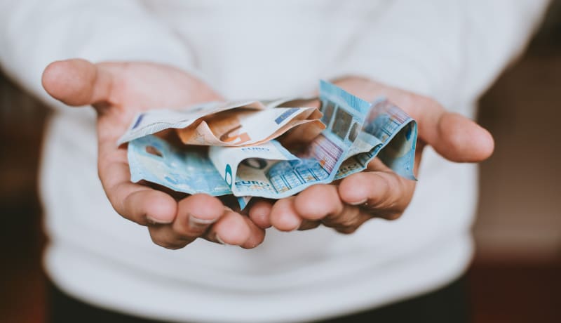 Photo of hands holding cash by Christian Dubovan on Unsplash
