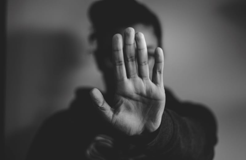 Photo of a woman holding up her hand in front of her face by Nadine Shaabana on Unsplash