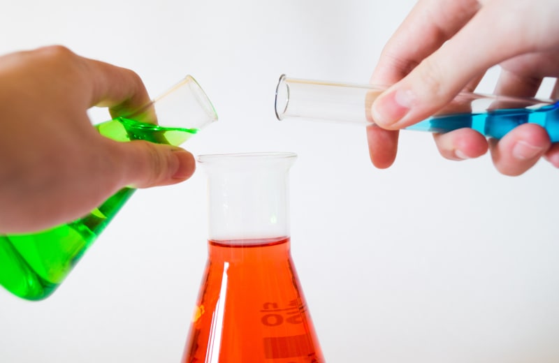 Photo of liquids being poured into science beakers by Alex Kondratiev on Unsplash