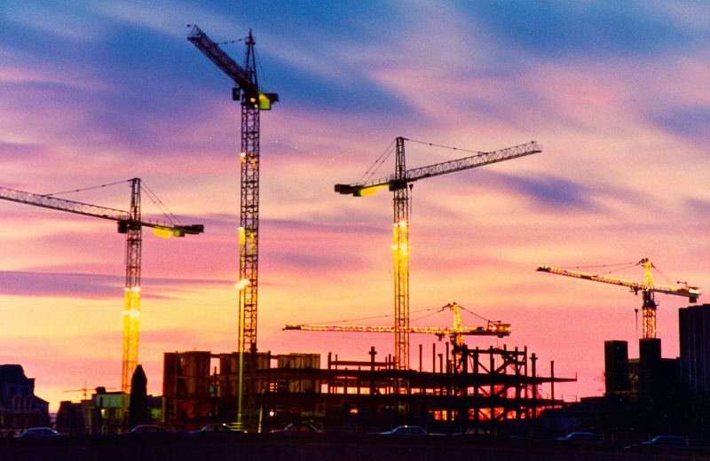 Photos of construction cranes in the evening sky by Danny Lau on Unsplash