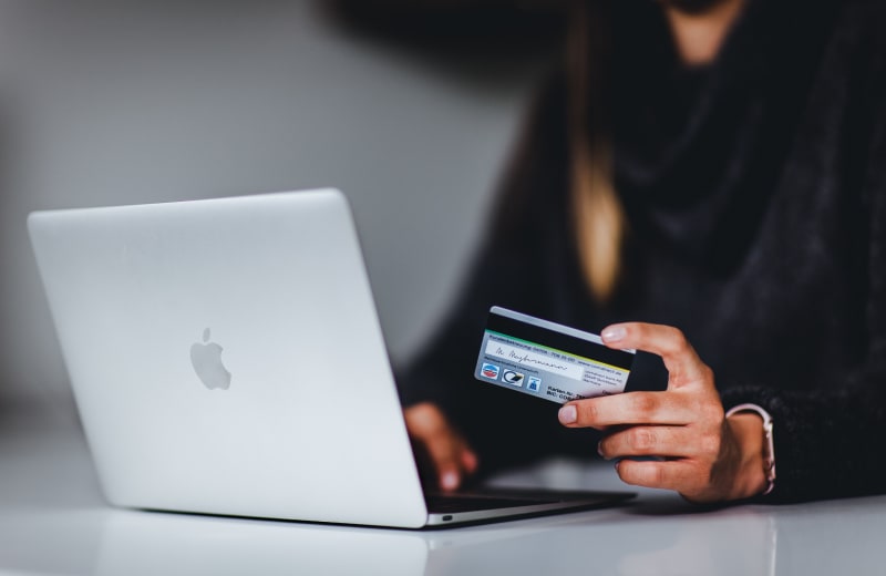 Photo of a man holding a credit card by Pickawood on Unsplash