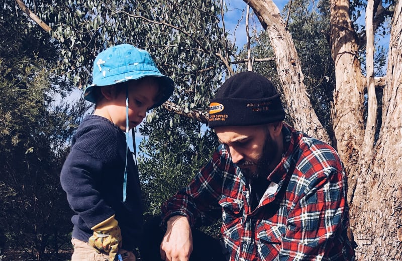 Photo of a father and his son planting a tree by Precious Plastic Melbourne on Unsplash