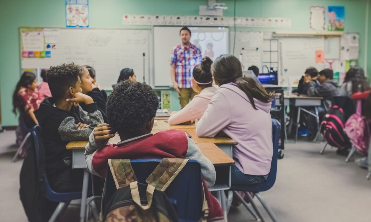 Photo of students sitting at desks in a classroom by Kenny Eliason on Unsplash