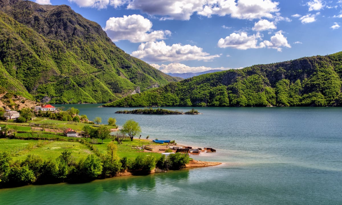 Photo of a lake and mountains in Albania by Yves Alarie on Unsplash