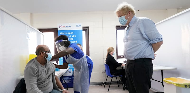 בוריס ג’ונסון, ראש ממשלת בריטניה, מתבונן בחיסון קורונה / צילום: Associated Press, Jon Super