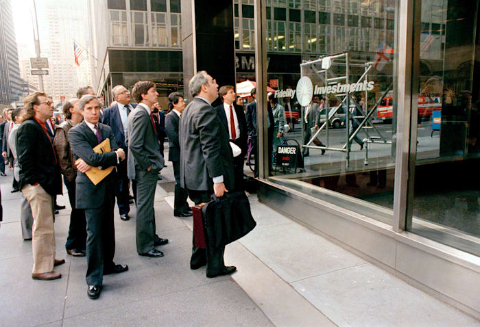 אנשים בניו יורק צופים בדיווחים על יום שני השחור בוול סטריט, 19 באוקטובר 1987 / צילום: Associated Press, G. Paul Burnett