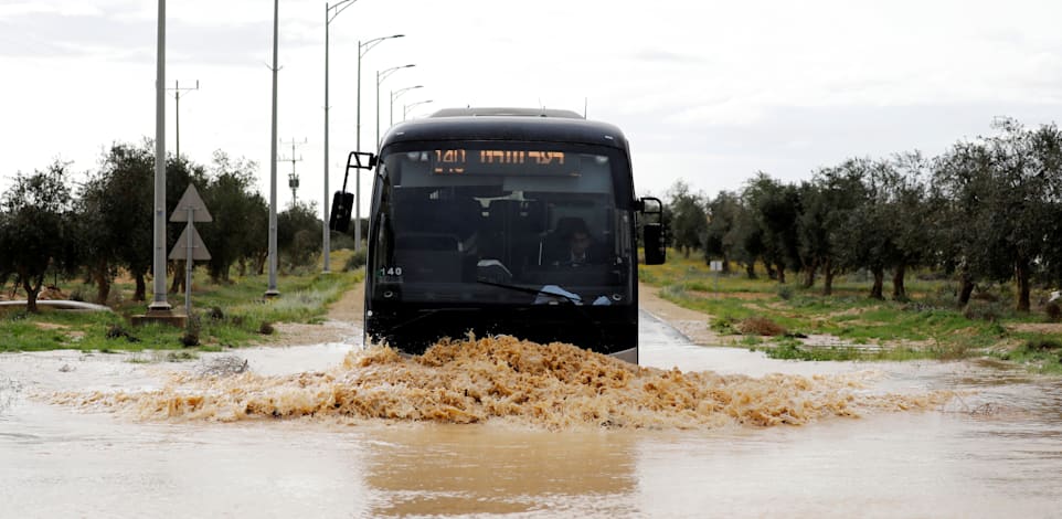 אוטובוס חוצה כביש מוצף ליד באר מילכה. ההצעה היא להקים אתרי ויסות / צילום: Reuters, Amir Cohen