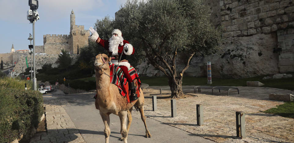 עיסא אניס קסיסיה מחופש לסנטה קלאוס בירושלים העתיקה / צילום: Associated Press, Mahmoud Illean