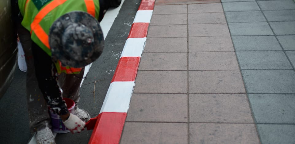 צובעים את שפת המדרכה באדום לבן / צילום: Shutterstock