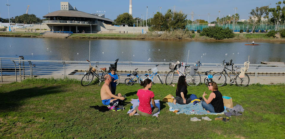 אנשים יושבים בפארק בתל אביב בתחילת ינואר / צילום: איל יצהר