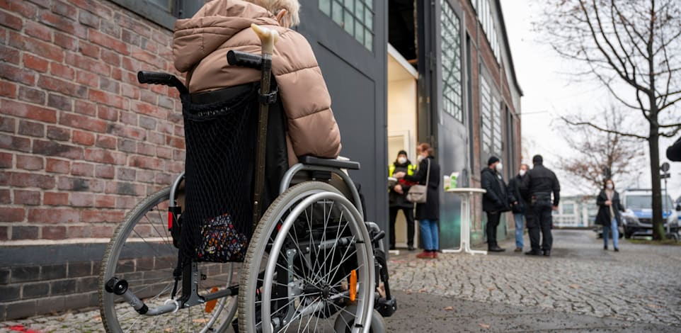 קשישה ממתינה בקור לחיסון נגד הקורונה, ברלין, בשבוע שעבר / צילום: Associated Press, Christophe Gateau
