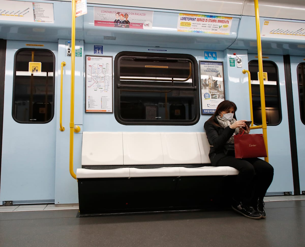 אישה עוטה מסכה ברכבת התחתית במילאנו, איטליה, ב-25 בפברואר / צילום: Associated Press, Antonio Calanni אישה עוטה מסכה ברכבת התחתית במילאנו, איטליה, ב-25 בפברואר / צילום: Associated Press, Antonio Calanni
