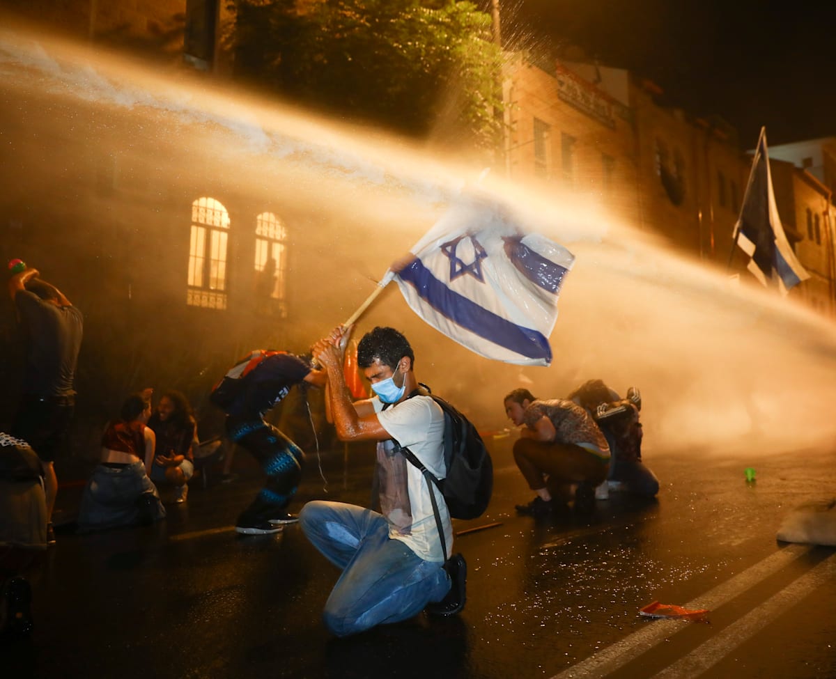 המשטרה מתיזה מים על מפגינים בבלפור, ב-18 ביולי / צילום: Associated Press, Oded Balilty המשטרה מתיזה מים על מפגינים בבלפור, ב-18 ביולי / צילום: Associated Press, Oded Balilty