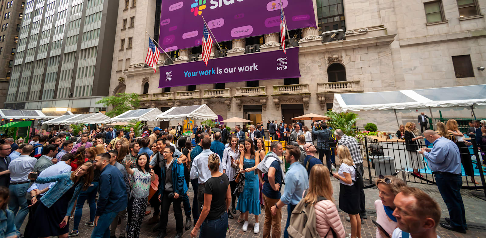 עובדי סלאק מצטלמים עם העוברים ושבים מחוץ לבורסת ניו יורק ביום ההנפקה ביוני 2019 / צילום: Shutterstock