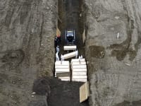 עובדים לבושים בבגדי מגן קוברים קורבנות של וירוס הקורונה בתעלה ליד ניו יורק / צילום: Associated Press, John Minchillo