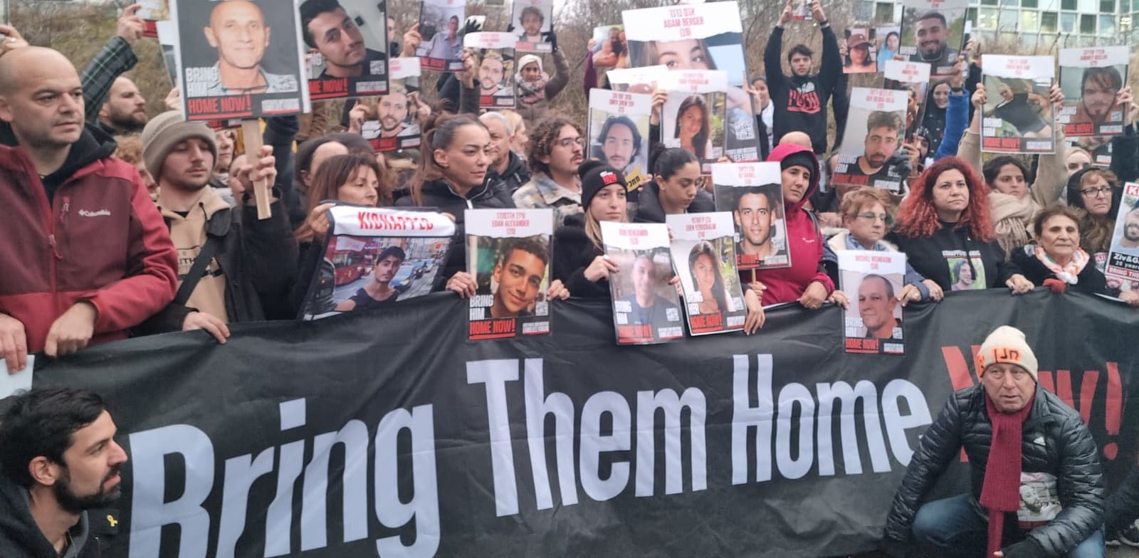 "משפחות החטופים על רקע בית הדין בהאג / צילום: ניצן שפיר"