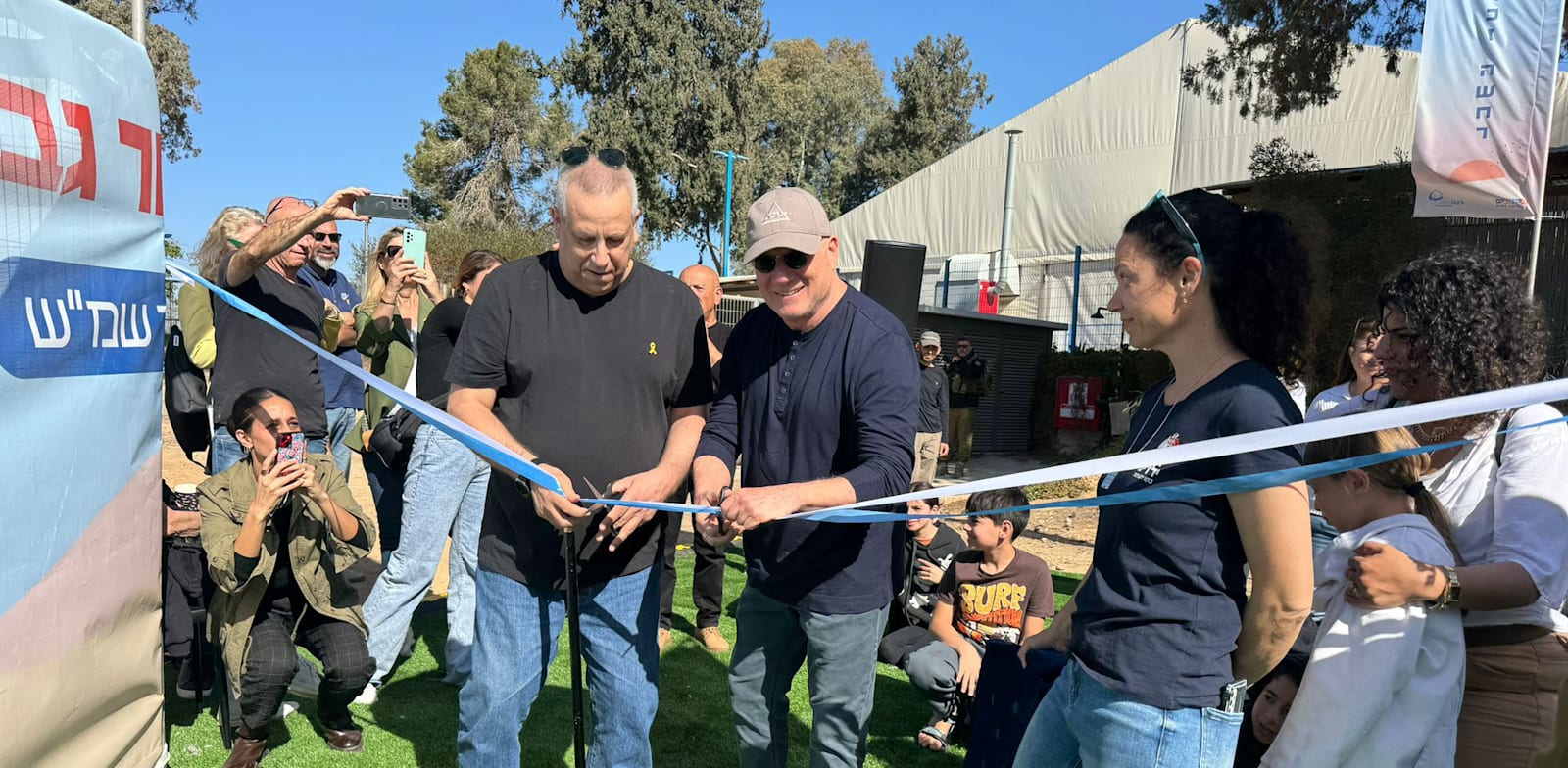 רוני דואק וגדי ירקוני גוזרים את הסרט בהשקת המתחם החינוכי / צילום: חוסן ילדינו