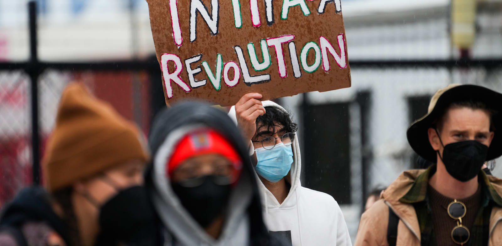 מפגין מניף שלט עם ''מהפכת אינתיפאדה'' בוושינגטון. תמיכות מפורשות באלימות / צילום: Associated Press, Lindsey Wasson