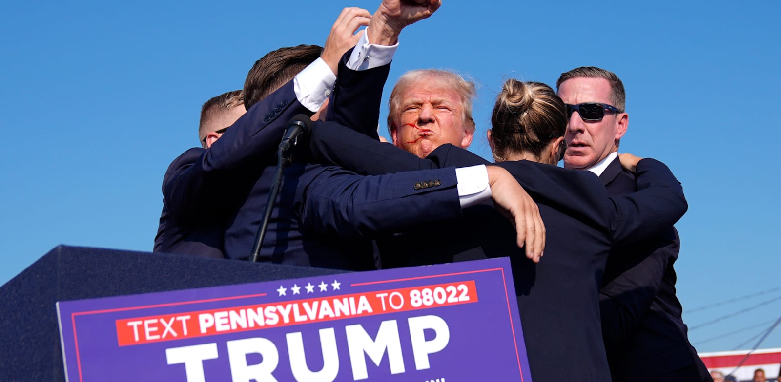 "טראמפ מוקף במאבטחים ומנופף באגרוף לאחר הירי, לפני שפונה מהמקום / צילום: Associated Press, Evan Vucci"