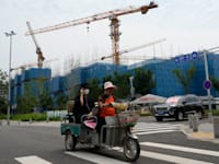 אתר בניה של חברת הנדל''ן קאנטרי גרדן ושלט שקורא לזכויות הקונים שנותרו ללא דירה. בעלי הדירות הקימו אוהלים ליד הפרויקט / צילום: ap, Ng Han Guan