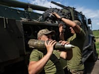 חייל אוקראיני נושא פגז 155 מ''מ / צילום: Associated Press, Evgeniy Maloletka