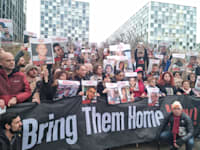 משפחות החטופים על רקע בית הדין בהאג / צילום: ניצן שפיר