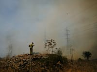כבאי מנסה לכבות את האש של השריפות שפרצו בגבול הצפון לאחר פיצוץ כטב''מים של חיזבאללה / צילום: ap, Ariel Schalit