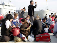 פליטים סורים יורדים מספינה בלגית בנמל באיטליה / צילום: Reuters, Antonio Parrinello