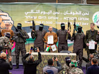 אור לוי, אלי שרעבי ואוהד בן עמי לפני העברתם מידי חמאס לידי הצלב האדום / צילום: Associated Press, Abdel Kareem Hana