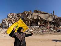 תומכת חיזבאללה על חורבות כפר כילא. הארגון השקיע 57 מיליון דולר בשיקום הבתים / צילום: ap, Hassan Ammar