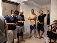 תושבים בתל אביב בחדר המדרגות לאחר השמעת האזעקה עם פתיחת המתקפה באיראן / צילום: Reuters, Itay Cohen