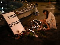 אישה מדליקה נרות נשמה בכיכר דיזנגוף, 13 באוקטובר 2023 / צילום: ap, Francisco Seco