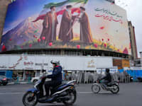 שלט חוצות המתאר את המנהיג העליון המנוח של איראן, עלי חמינאי מגיש את דגל המדינה לבנו ויורשו מוג'תבא / צילום: ap, Vahid Salemi