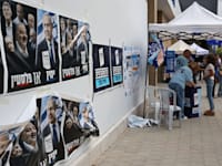 פעילים עומדים מחוץ לקלפי בהרצליה / צילום: Reuters, Gil Cohen