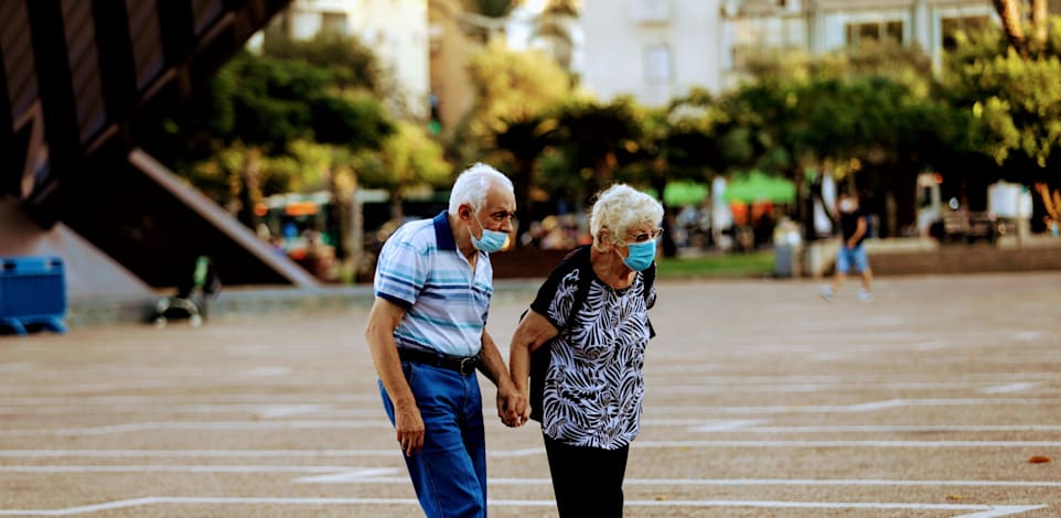 זוג קשישים הולכים בזמן קורונה עם מסכה / צילום: שלומי יוסף